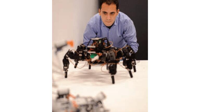 Electronics student Luis Fuente
operating a Hexapod robot.