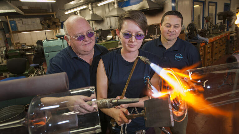 Tony Mercer, Head Glassblower, YorLab (left) and Alex Davis, Managing Director, YorLab watch Eloise Alsop, trainee Glassblower