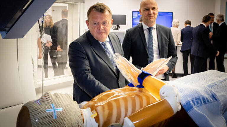 Danish Prime minister Lars Løkke Rasmussen (left) and the chair of the regional council Anders Kühnau (right) had the chance to say hello to Anton the doll, who played the role of patient during the inauguration of the centre. Photo Credit: Tonny Foghmar/AUH.