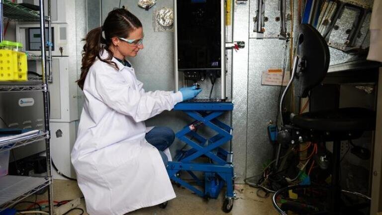 Tess Eidem pumps allergens into a chamber to study the impact of UV light on them. Credit: Patrick Campbell/CU Boulder