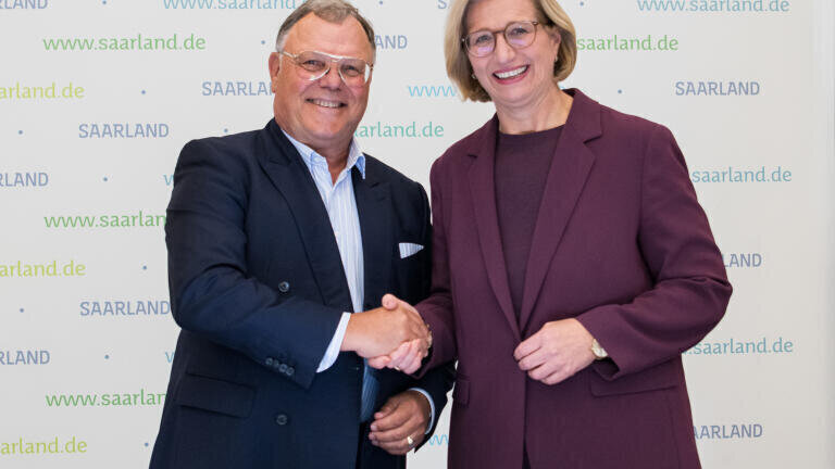 Minister-President of Saarland Anke Rehlinger and Senator h.c. Udo J. Vetter, Chairman of the Advisory Board and member of the owner family, with the model of the new, multi-phase production site in Saarlouis. Credit: Saarland State Chancellery / Jennifer Weyland